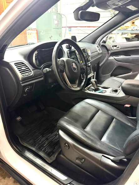 Jeep front cabin after detailing with clean surfaces, seats and floor mat