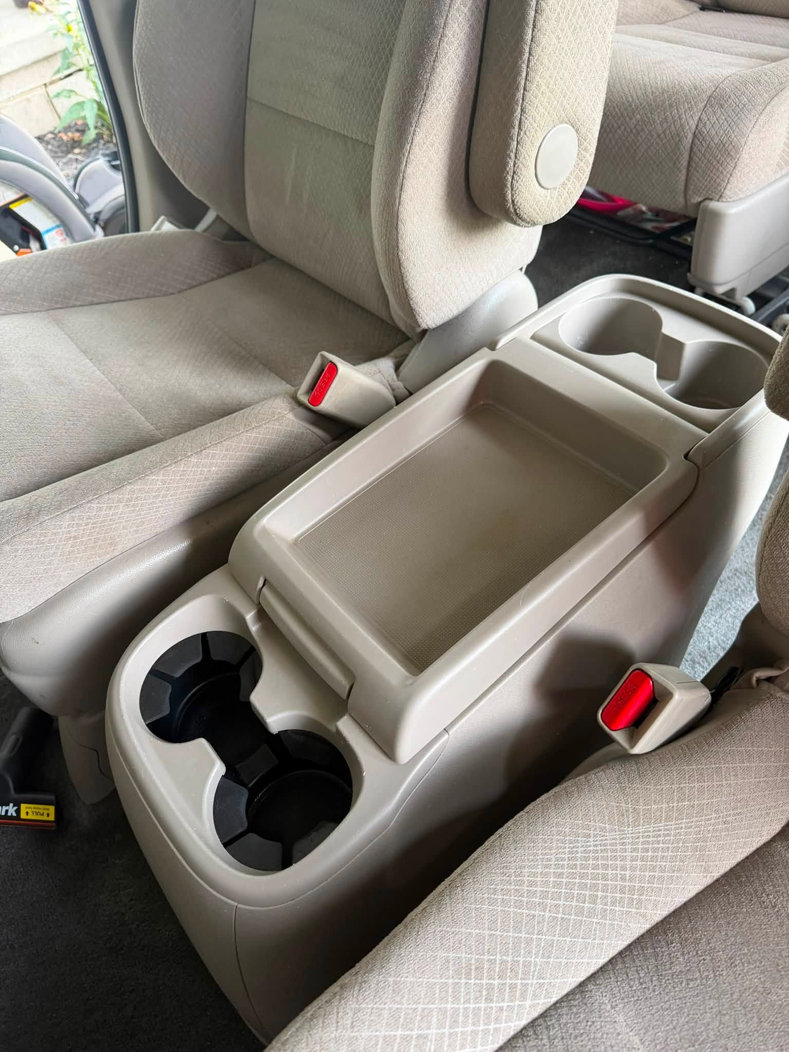 Minivan center console after detailing with clean cupholders, tray and surrounding seats