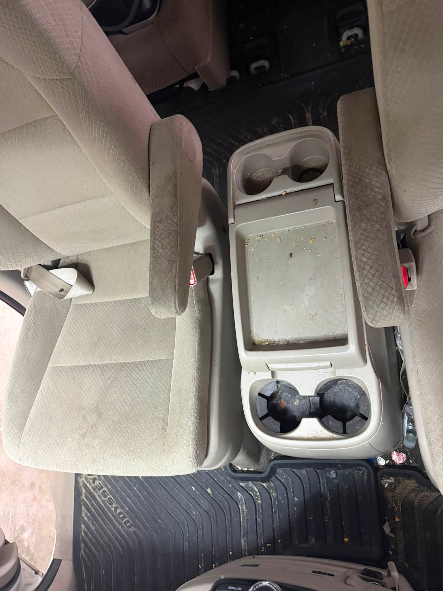 Minivan center console before detailing with food residue, dirt and stained cupholders