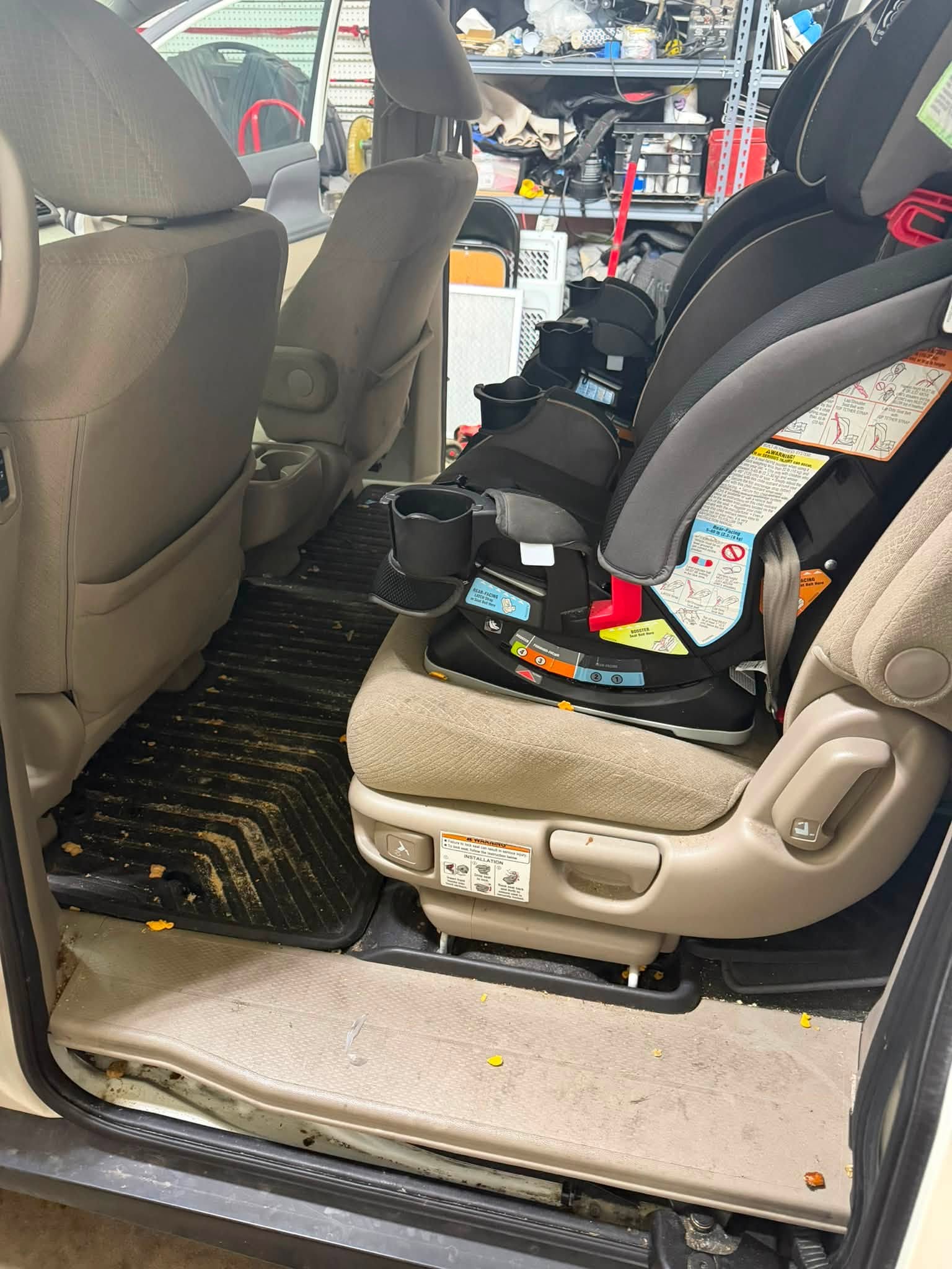 Minivan passenger area before detailing with car seats, food debris and a dirty floor mat