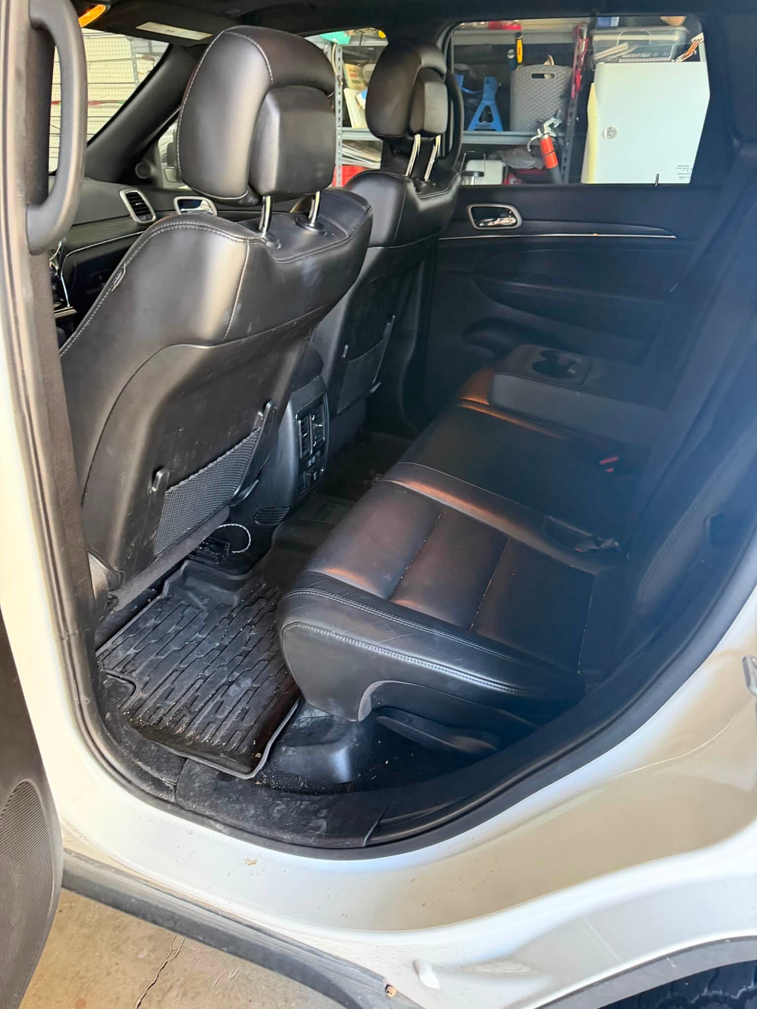 Jeep rear seating area before detailing with dirt around the floor and door sill
